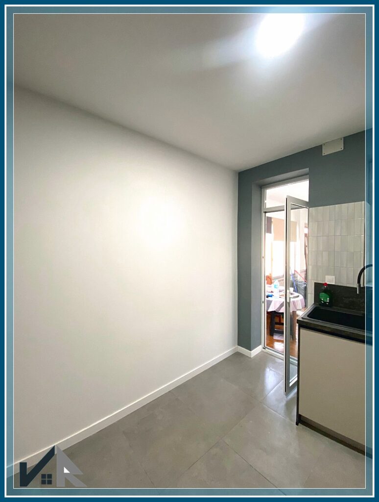 Pared frente a mobiliario de cocina pintada en color blanco en combinación con azul