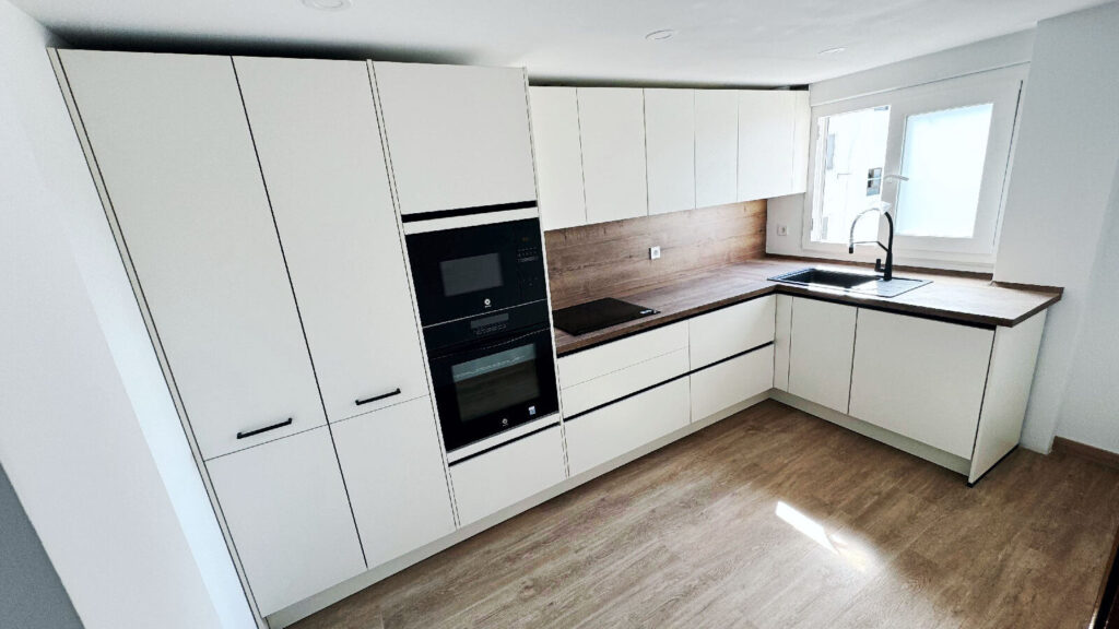Cocina cuadrada con mobiliario en L en reforma integral de una vivienda realizada en Valencia para clientes de Madrid