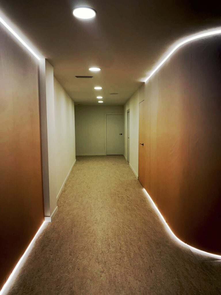 Detalle de panelados e iluminación en reforma de local para clínica