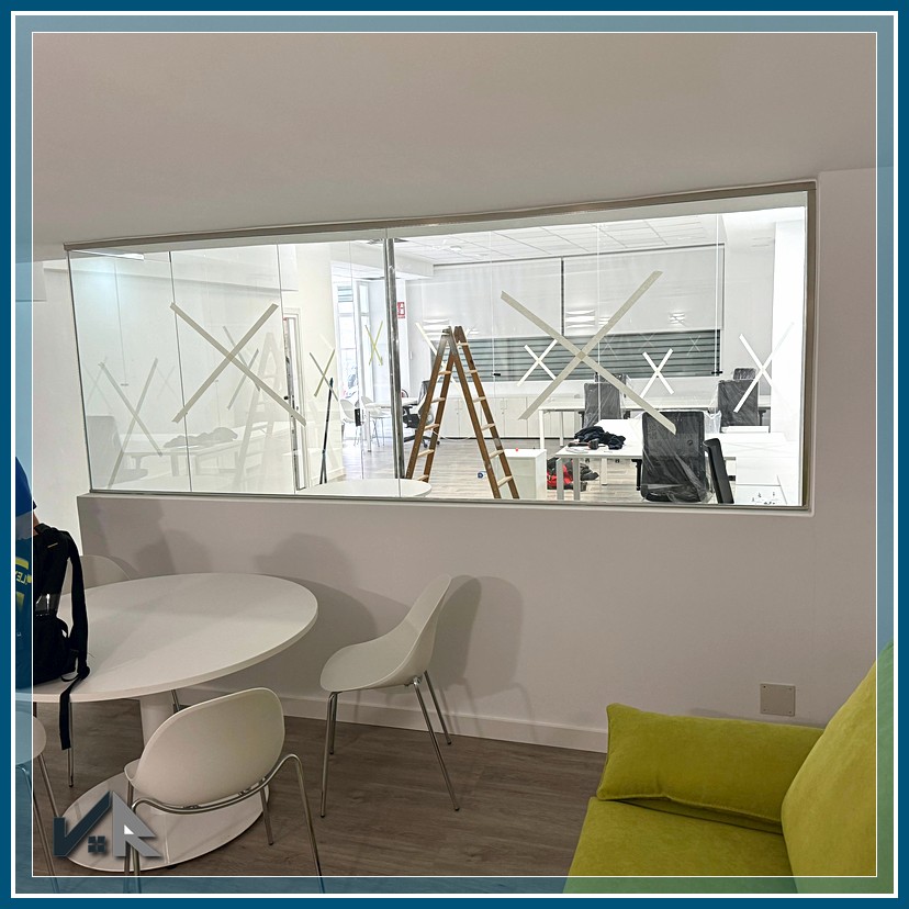 Espacio de reunión con mampara divisoria y puerta de cristal | Meeting space with glass partition and door